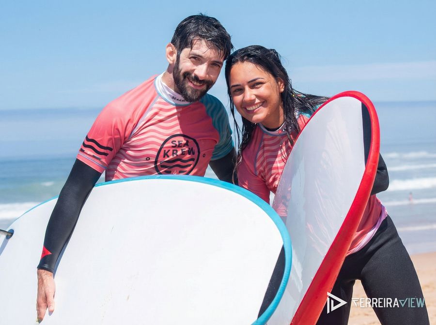 Casal a sorrir com as pranchas depois de uma aula de surf da Sea Krew
